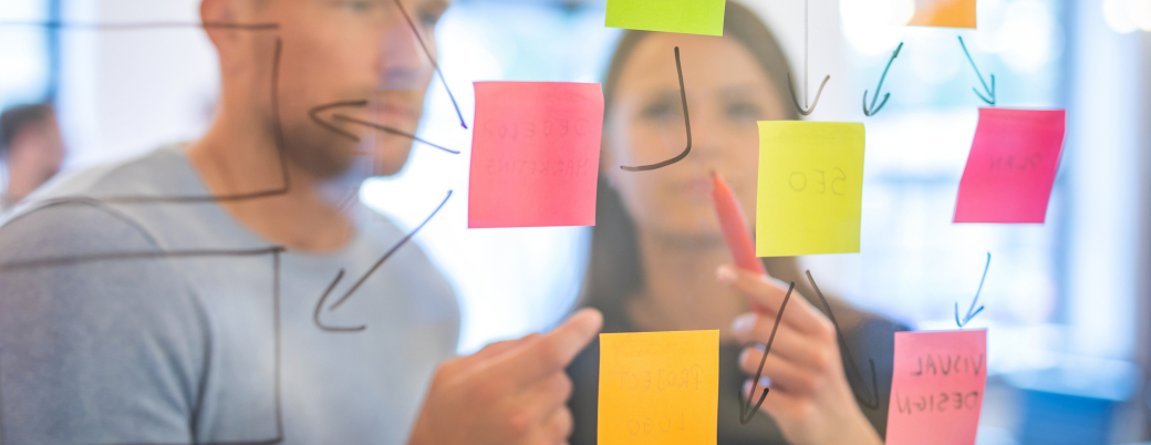 deux jeunes installent des post-it sur une vitre