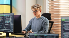 jeune homme travaillant devant un ordinateur 