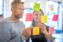 deux jeunes installent des post-it sur une vitre 