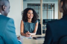 jeune femme travaillant dans la vente face à deux clients